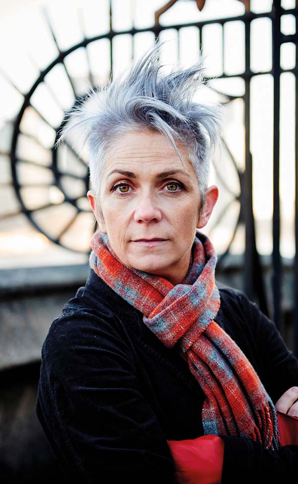 Image of white woman with short grey hair, wearing a scarf